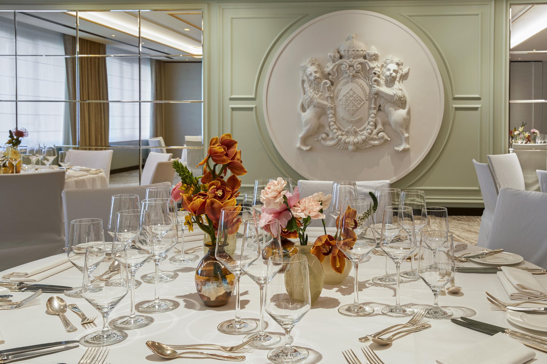 Elegant banquet table with orange floral centerpieces at Hotel Vier Jahreszeiten Kempinski München