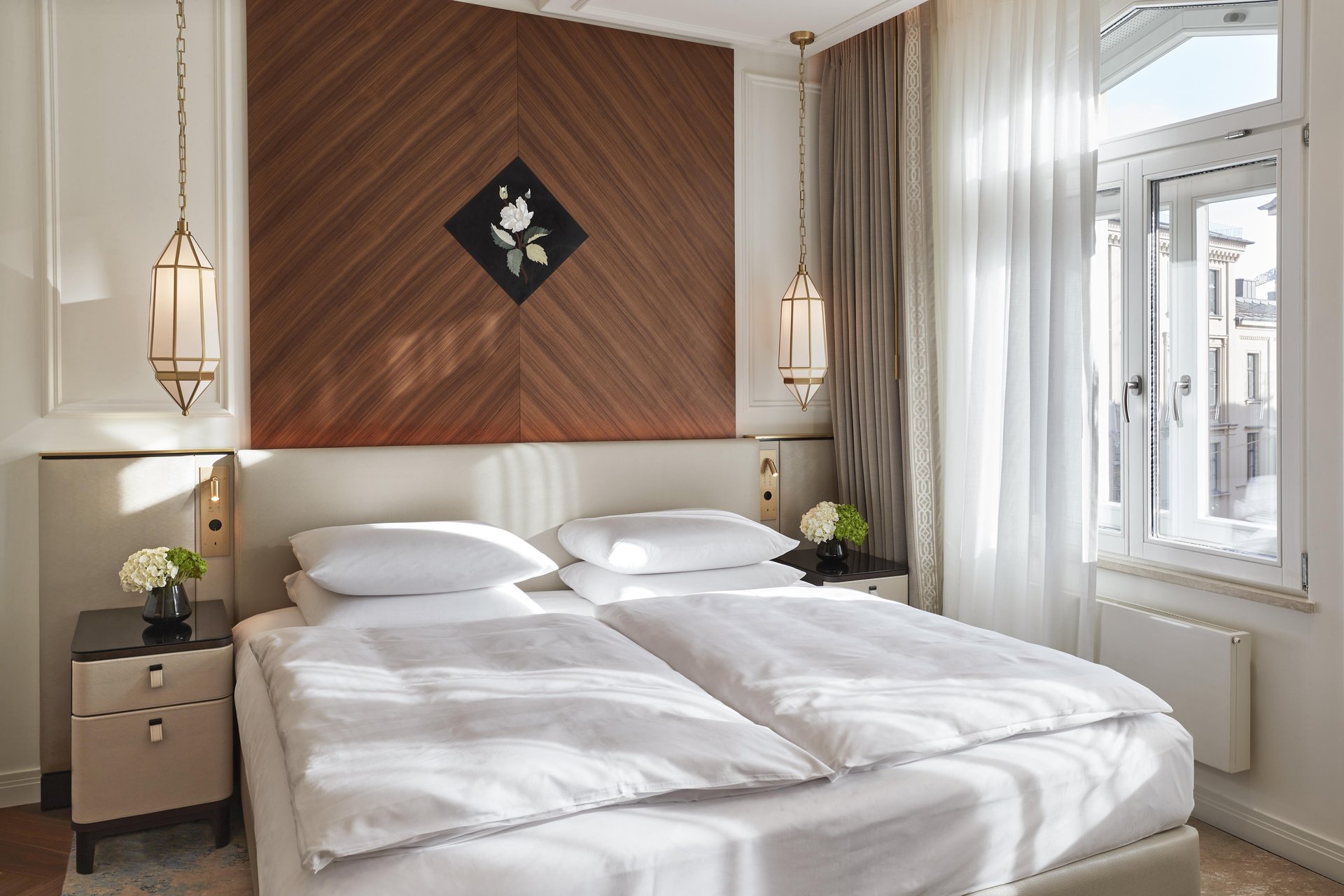 Signature Two Bedroom Suite with chevron wood headboard and pendant lights at Hotel Vier Jahreszeiten Kempinski München
