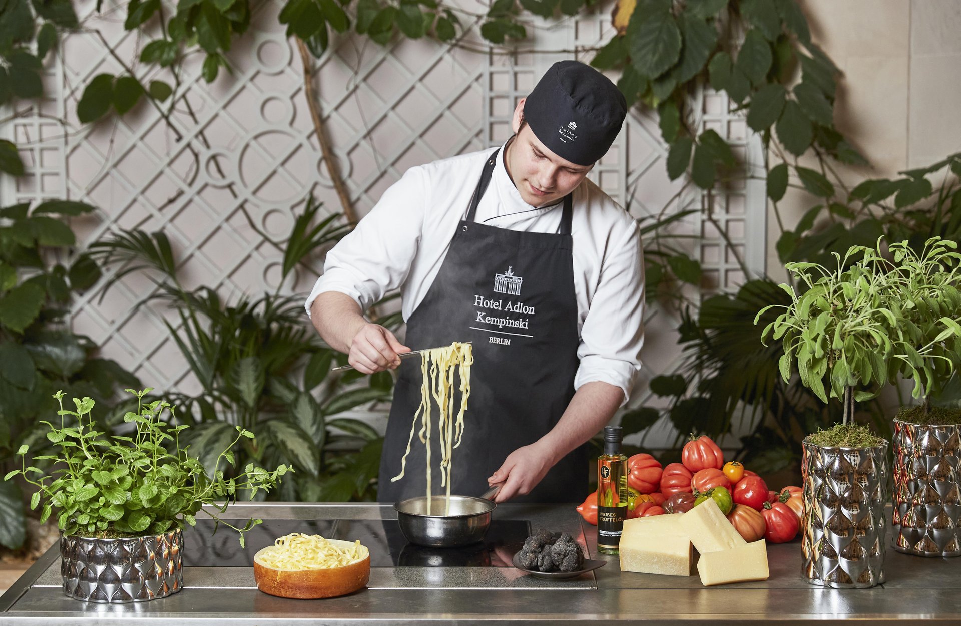 A chef prepares pasta at a live cooking station