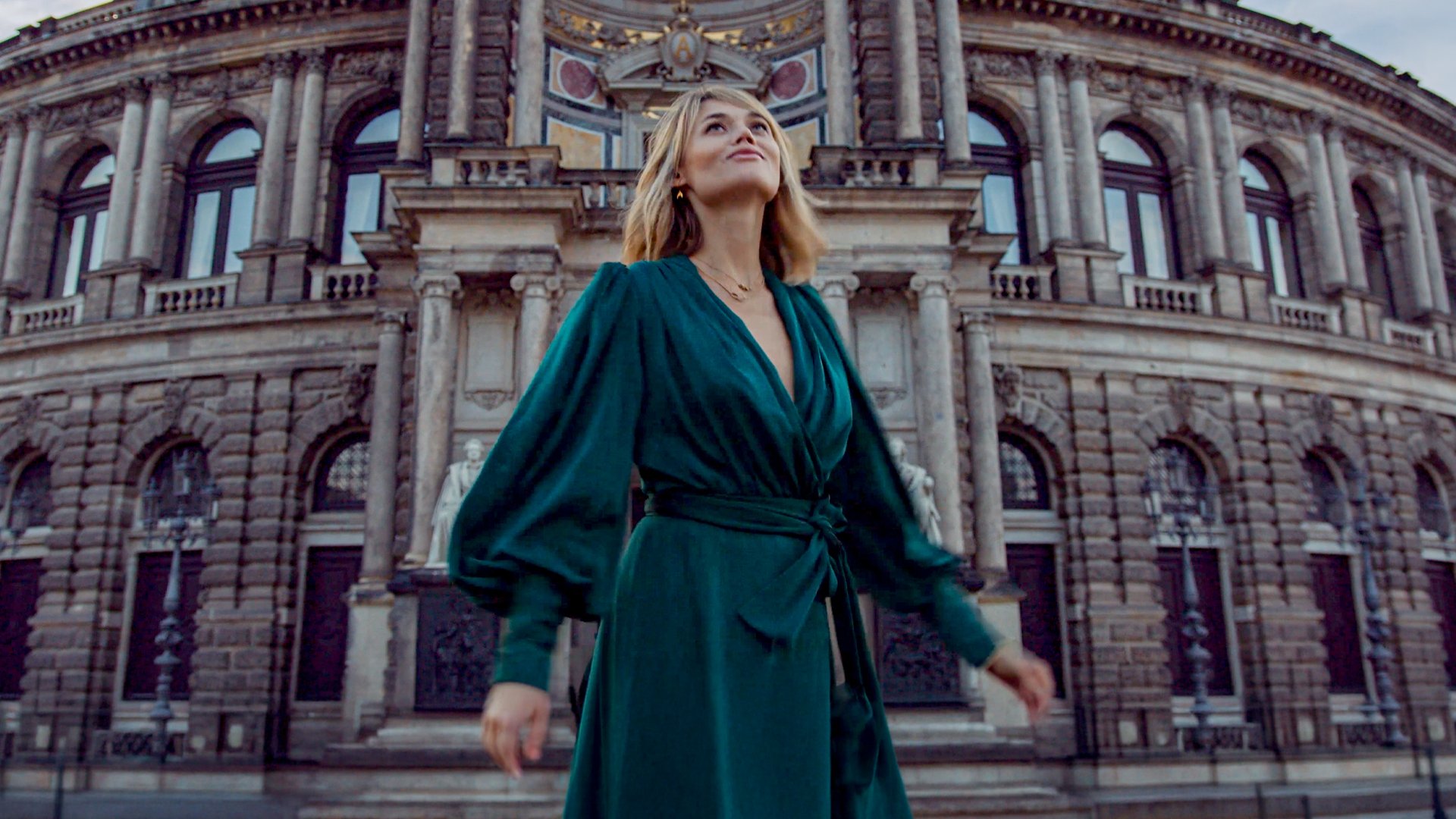 woman in green dress exploring a city
