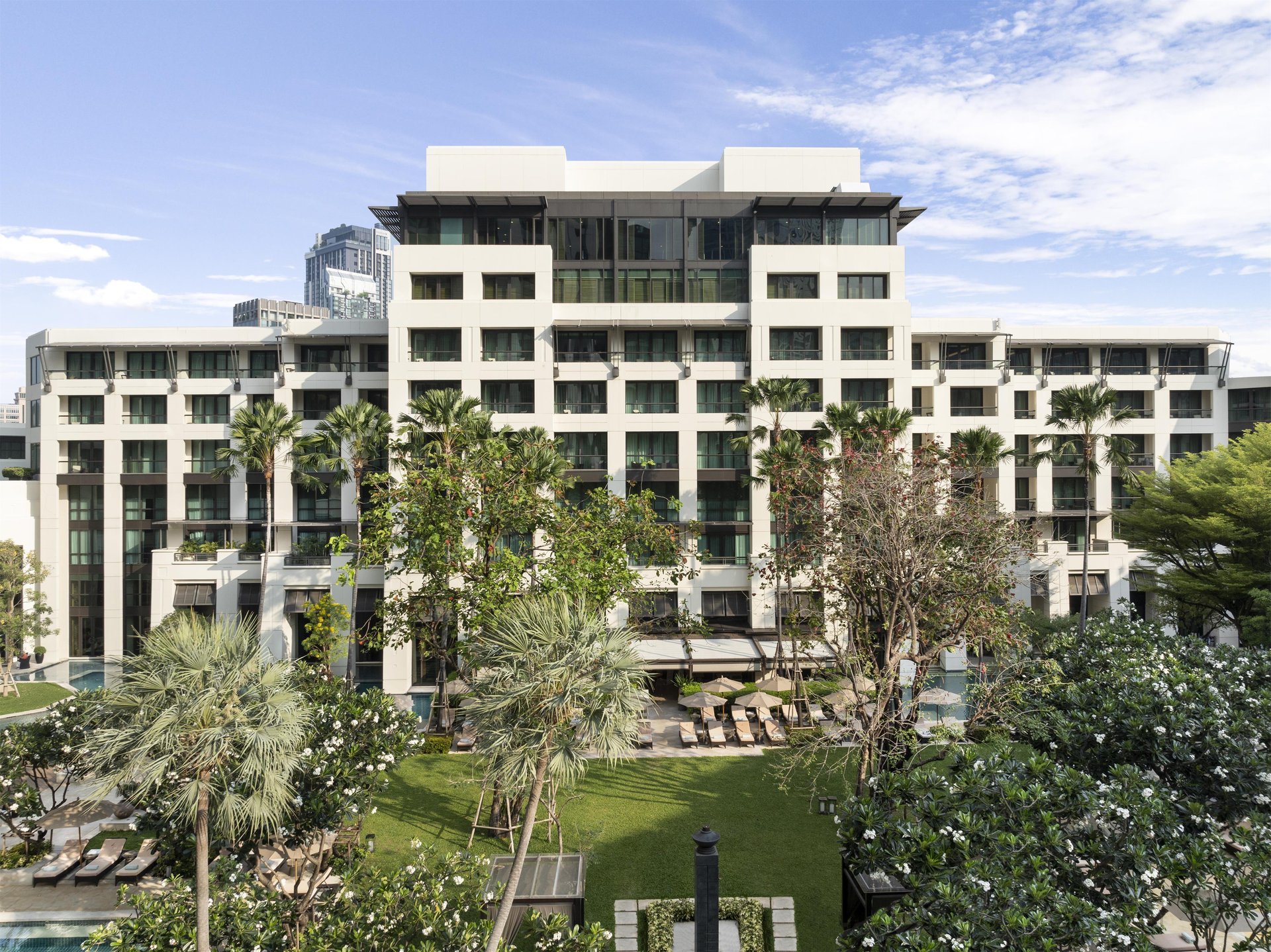 Aerial view of Siam Kempinski Hotel Bangkok luxury resort wings, tropical gardens, and swimming pools in the city center