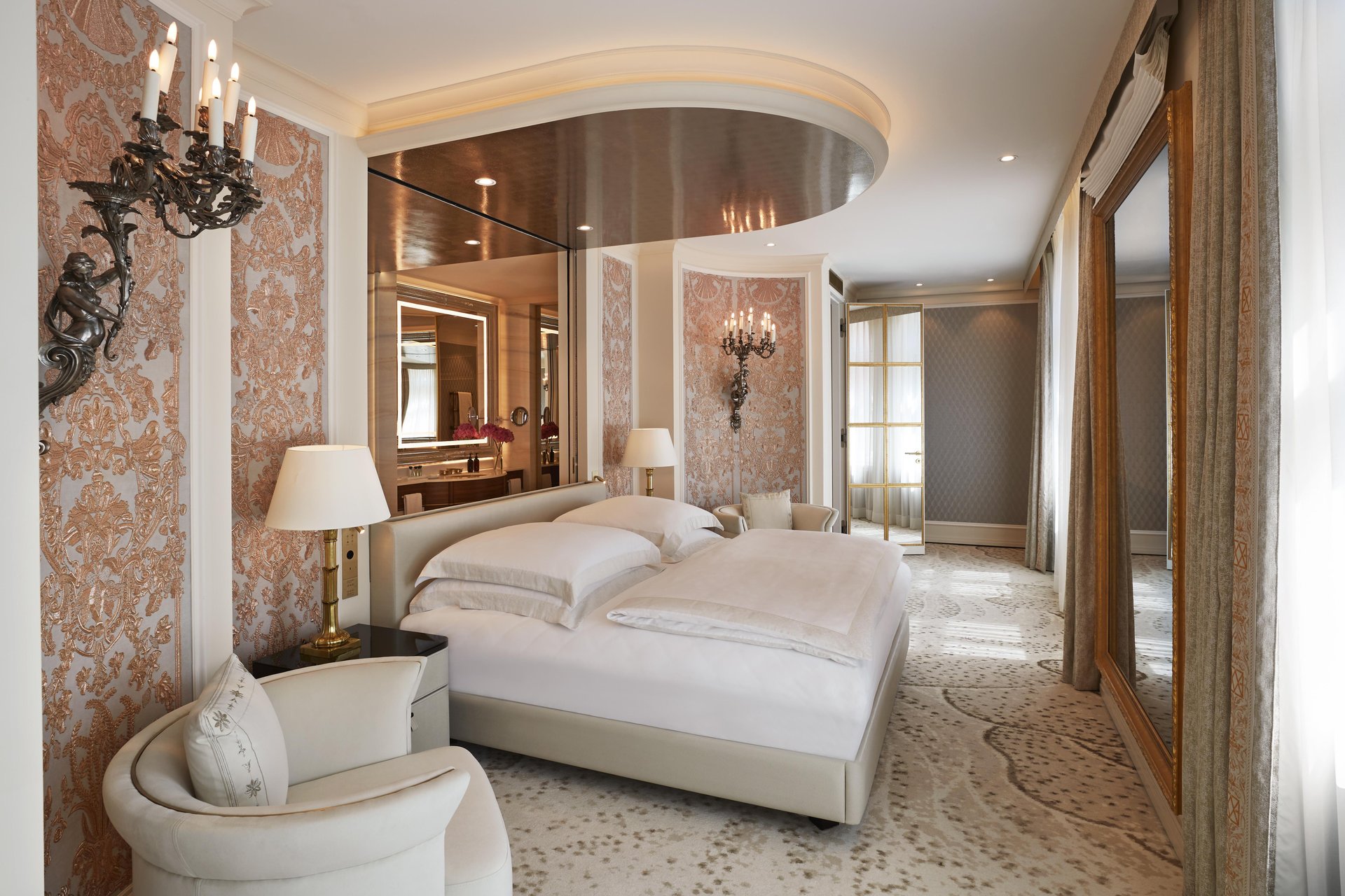 Ornate Ludwig Suite bedroom with silk wall panels and candelabras at Hotel Vier Jahreszeiten Kempinski München