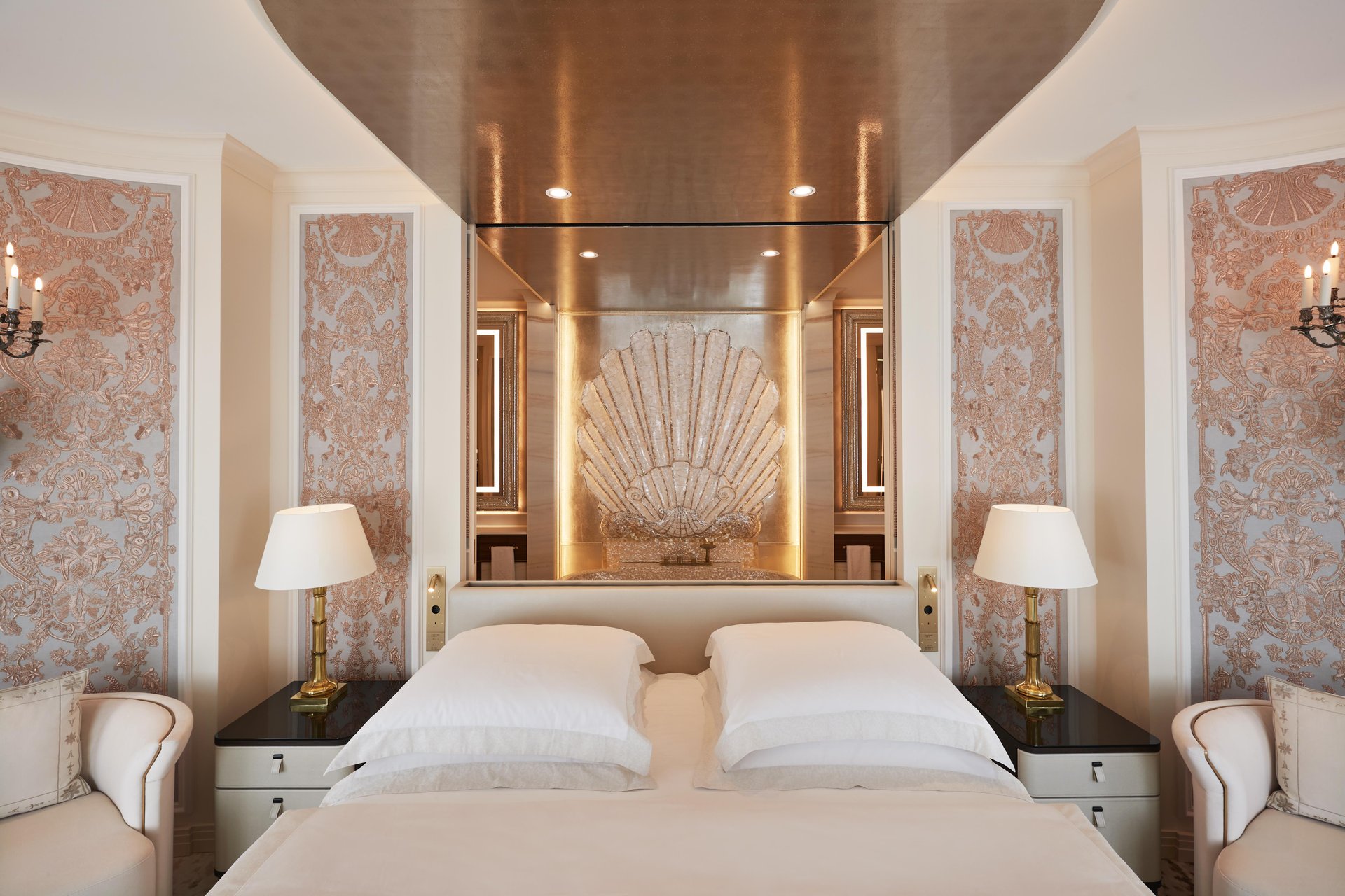 Ornate master bedroom with gold shell headboard and silk wall panels at Hotel Vier Jahreszeiten Kempinski München