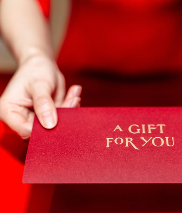 Lady in Red holding a printed red gift certificate