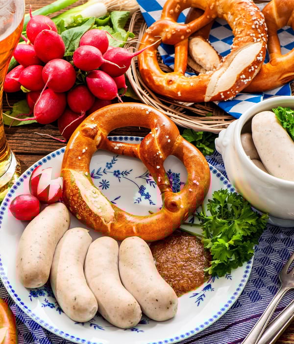 Authentic Bavarian Weisswurst with Obatzter, pretzel, and beer in an alpine chalet.