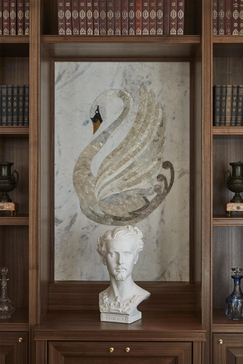King Ludwig II bust and marble swan inlay in a library at Hotel Vier Jahreszeiten Kempinski München